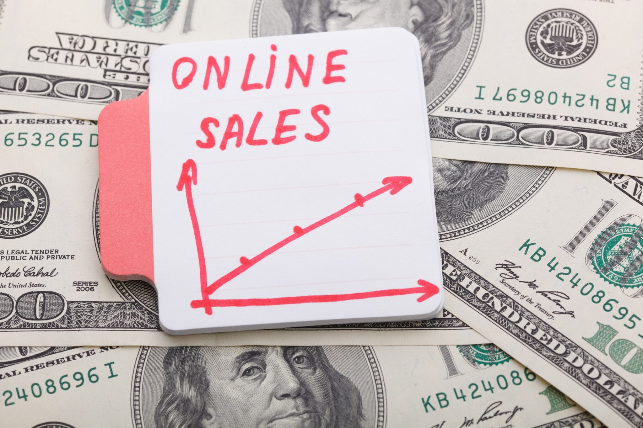 55535116_m_normal_none Boost website sales - a post-it-note sits on dollar bills with 'online Sales' written on it and a graph showing an increase